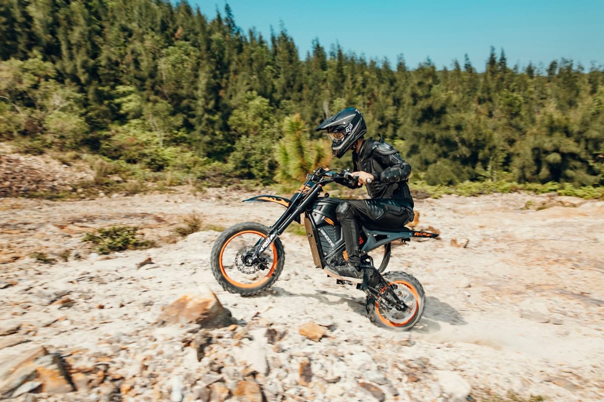 Rider on a dirt bike navigating rocky mountain terrain